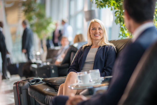 Business people sitting on chair and discussing at airport departure area.